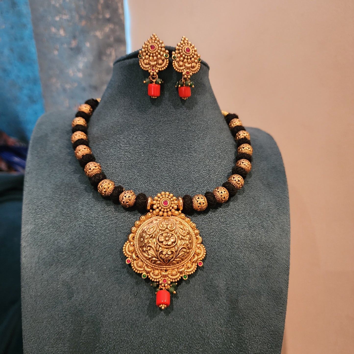 Amrutha-Black thread neckset with nakshi ball and coral bead