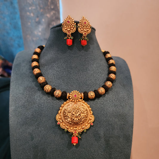 Amrutha-Black thread neckset with nakshi ball and coral bead